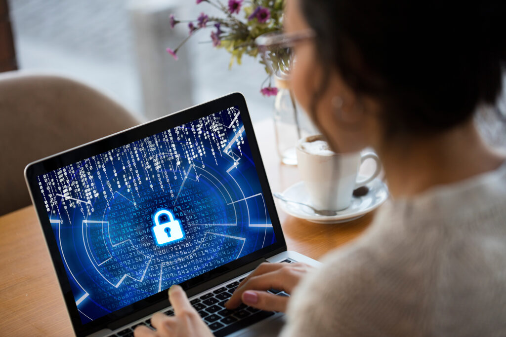 EDR vs. antivirus software may mean more powerful cybersecurity, as depicted by this woman looking at a monitor with a picture of a lock on the screen.