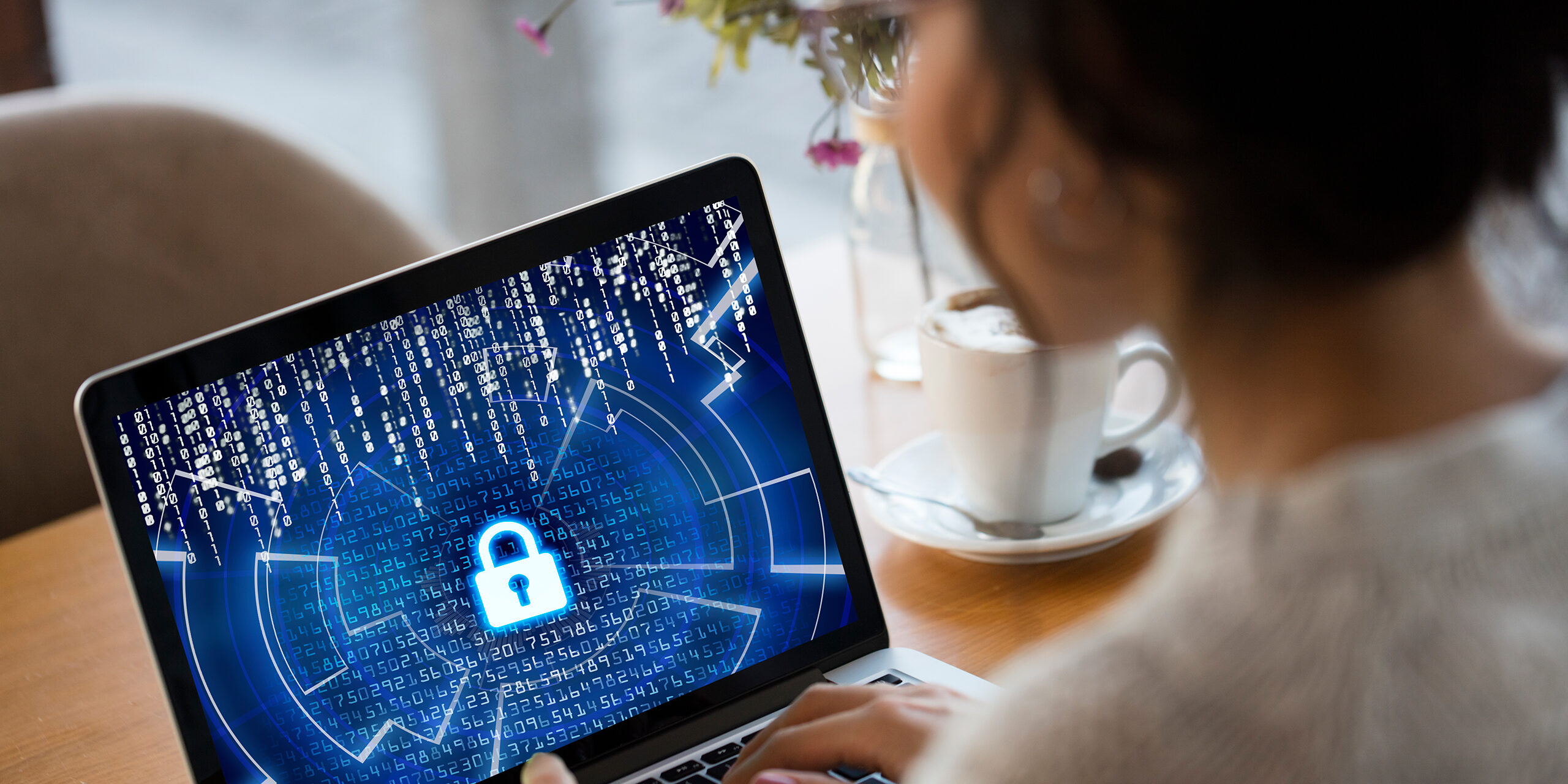 EDR vs. antivirus software may mean more powerful cybersecurity, as depicted by this woman looking at a monitor with a picture of a lock on the screen.